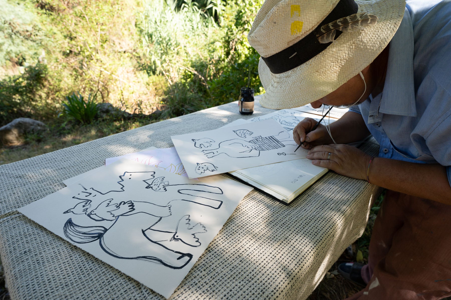 Painter Martin Finnin working on black ink drawings in the countryside in Italy 